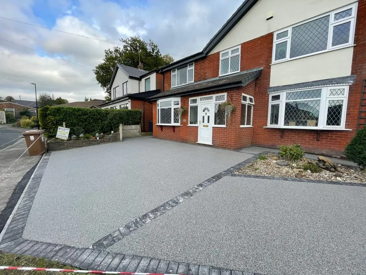 Grey resin driveway in front of a semi-detached house