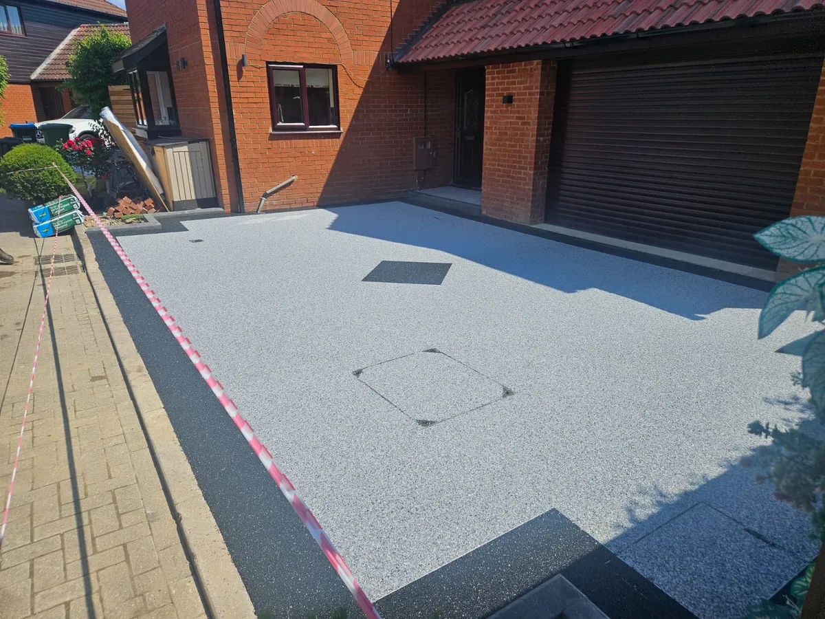 C 06 silver grey resin driveway beside a garage